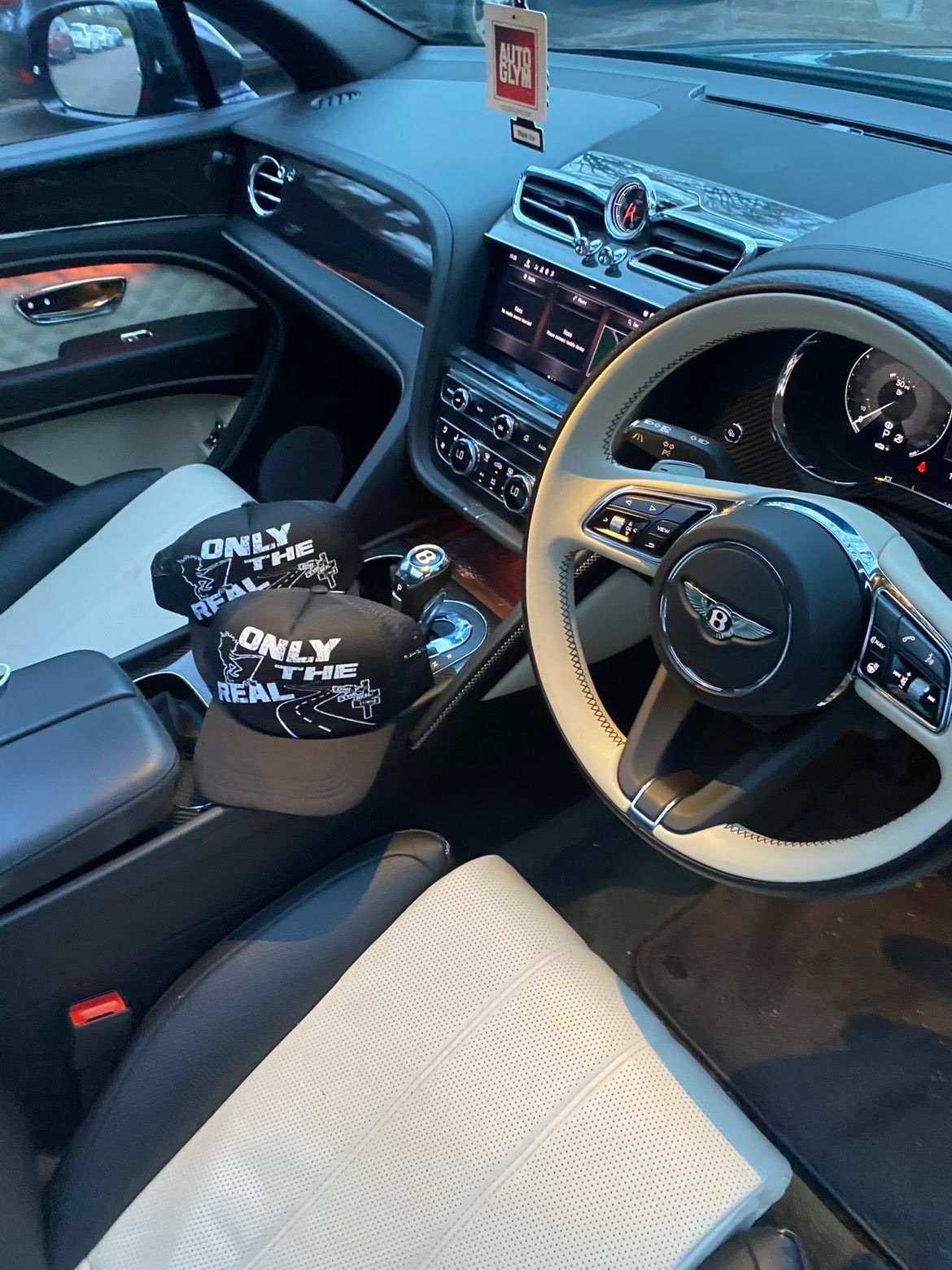 Only The Real caps lined up inside a luxury car.